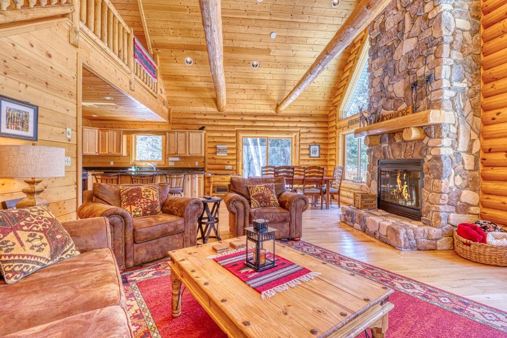 ein Wohnzimmer mit einem Steinkamin in einer Blockhütte in der Unterkunft Lazy Bear Lodge in Conway
