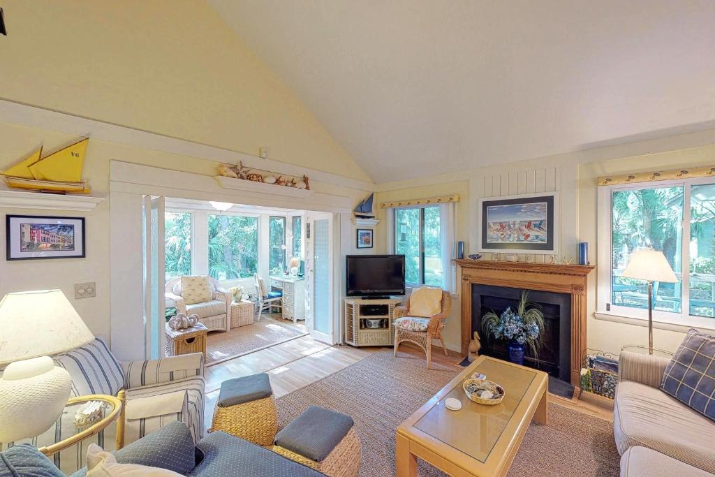 a living room with a couch and a fireplace at 443 Oceanwood Cottage in Kiawah Island