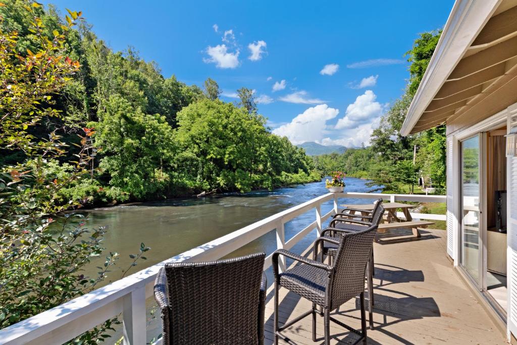 una fila de sillas sentadas en un balcón con vistas al río en 2 Bed 1 Bath Vacation home in Sylva, en Sylva