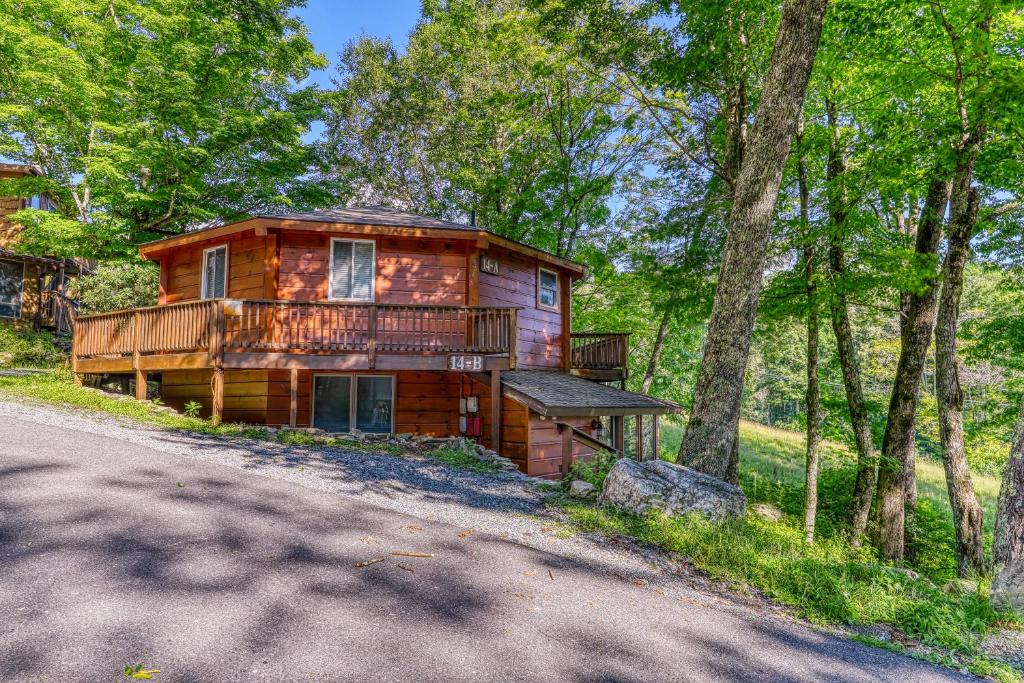 a log cabin in the woods next to a road at Slopesider 14B in Sugar Mountain