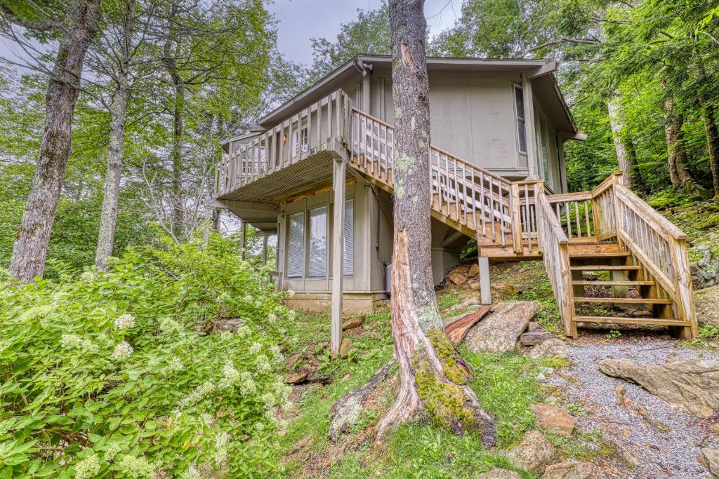 a cabin in the woods with a large deck at Slopesider 26 in Sugar Mountain
