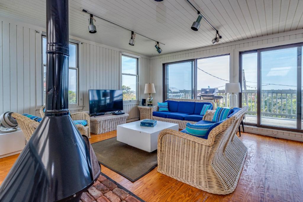 uma sala de estar com um sofá azul e cadeiras em Robbins Rest Retreat em Ocean Beach