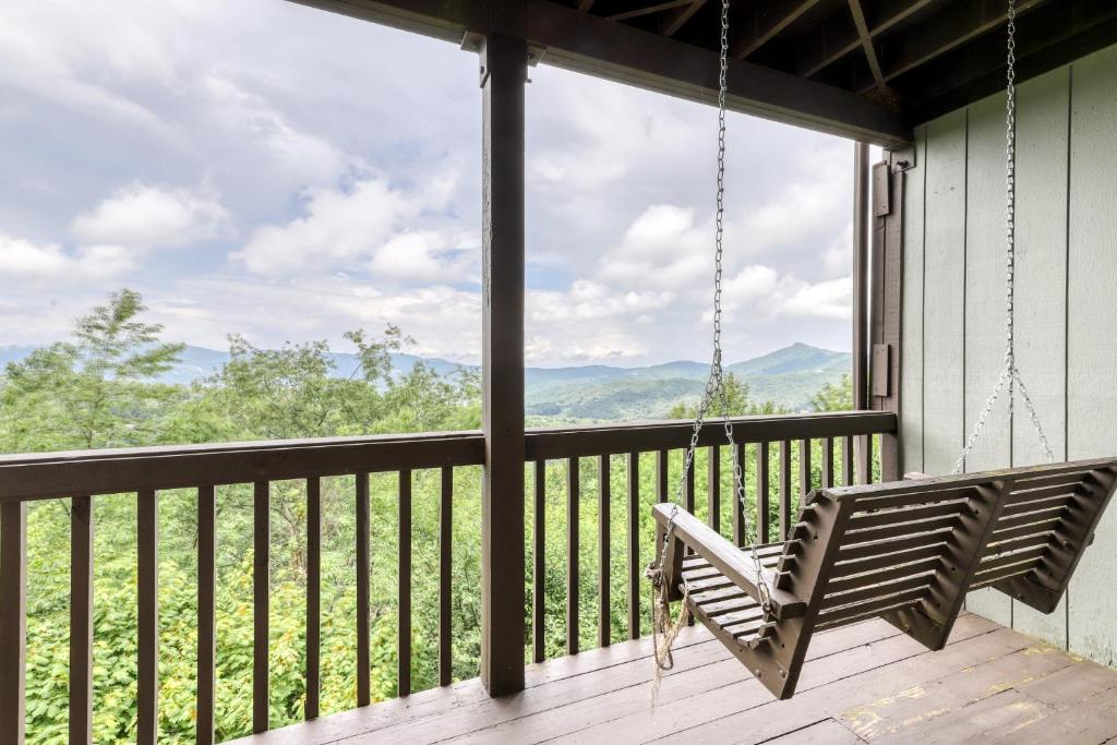 a porch with a swing and a view of the mountains at Skyleaf 703 in Sugar Mountain