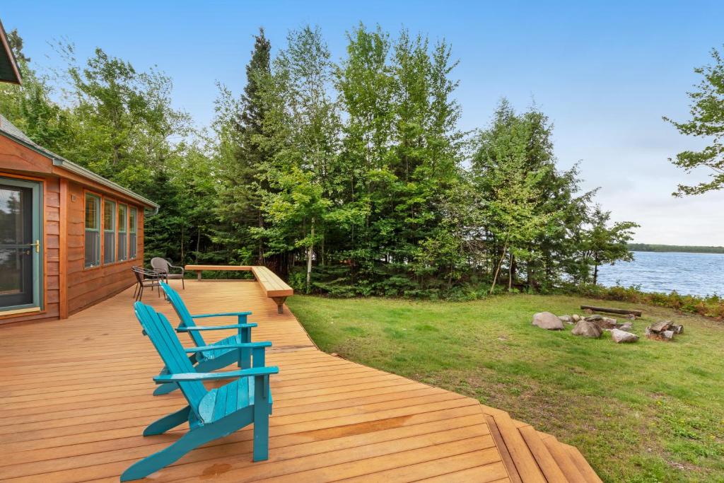 a deck with two blue chairs on the side of a house at Swan Cove in Hartley