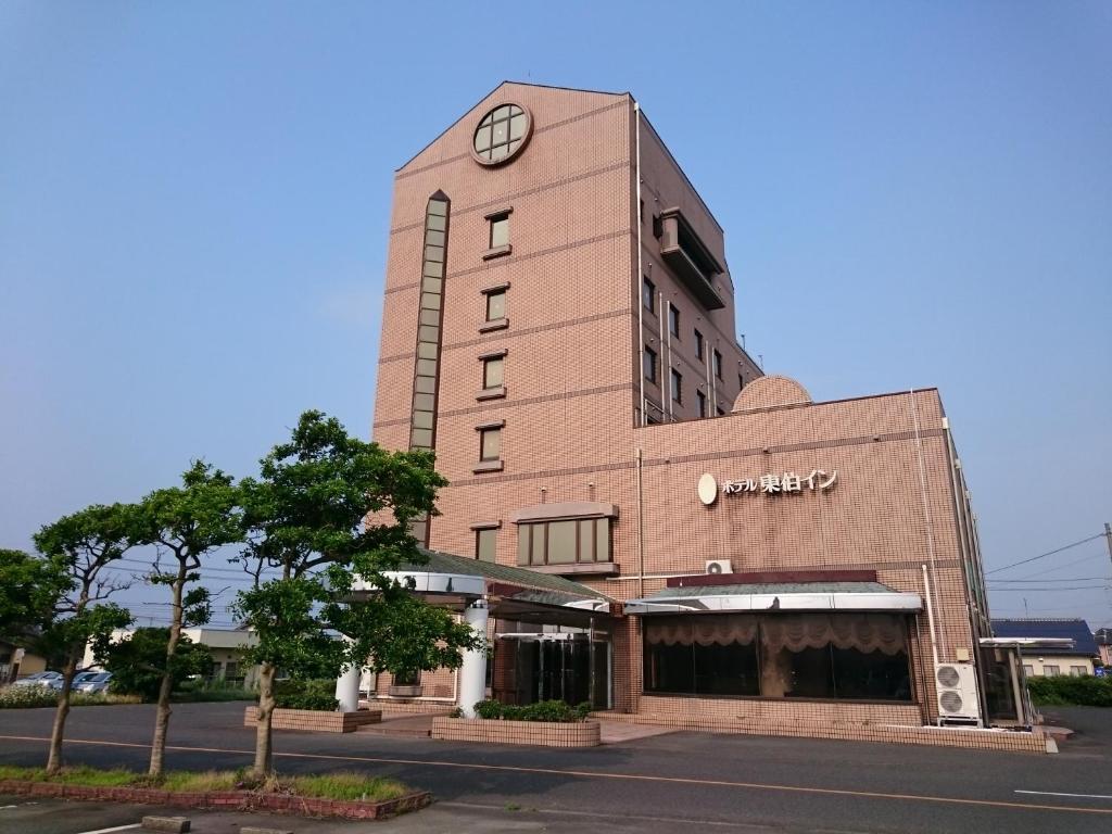 ein Gebäude mit einer Uhr auf der Seite in der Unterkunft ホテル東伯イン in Kotoura