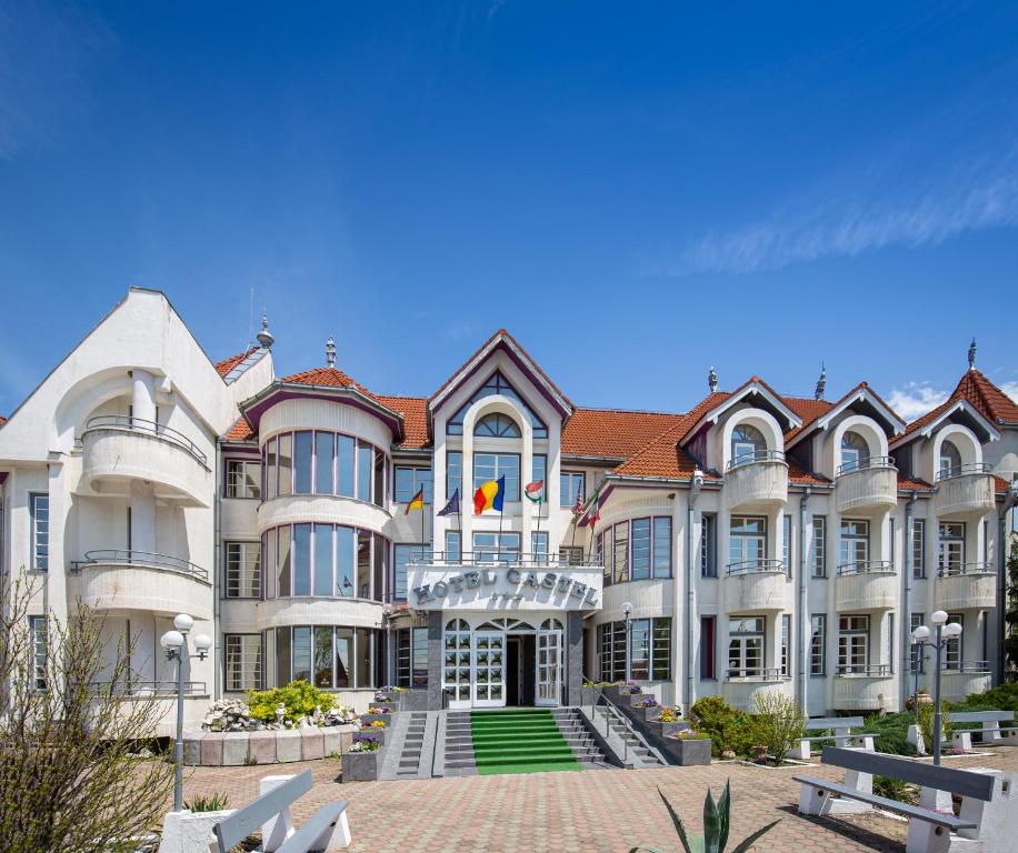 un gran edificio blanco con techo rojo en Hotel Castel en Sfântu-Gheorghe