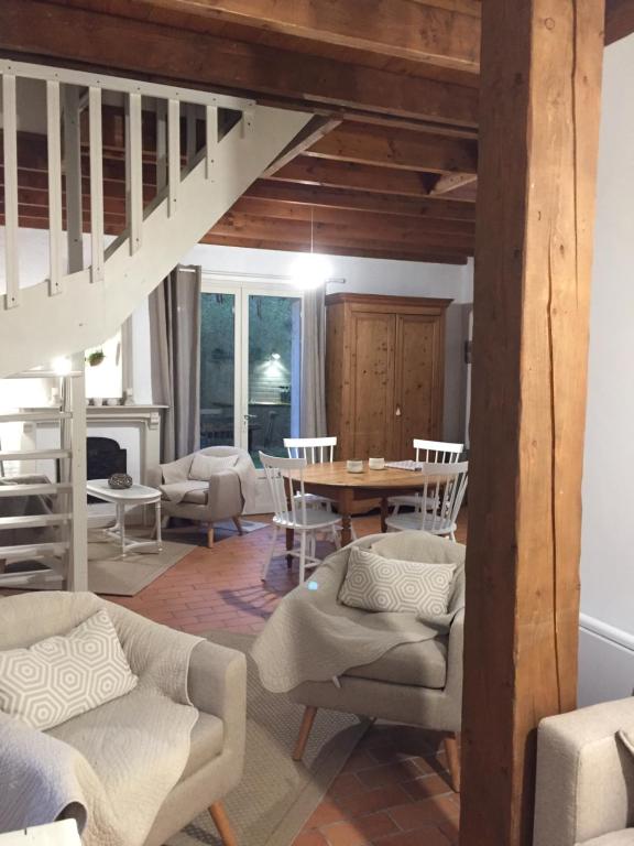uma sala de estar com uma escada e uma mesa e cadeiras em Gîte du Rouard em Camiers