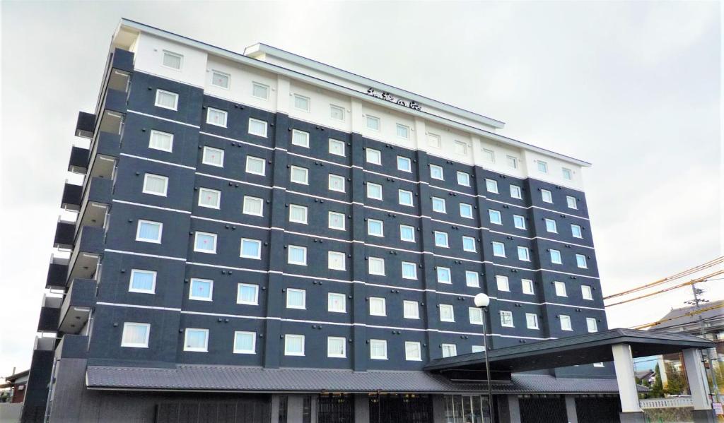 a large building with many windows on the side of it at Route Inn Grantia Wakuranoyado Igauenojomae in Iga