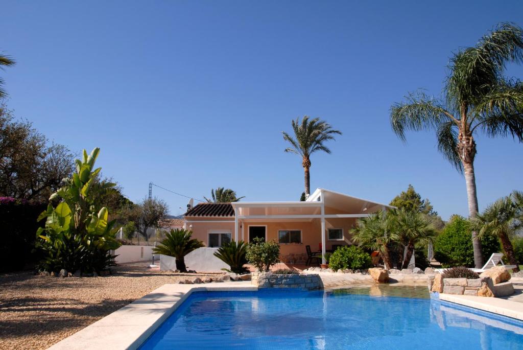 een huis met een zwembad en palmbomen bij Mi Tiempo in Muntanya la Sella