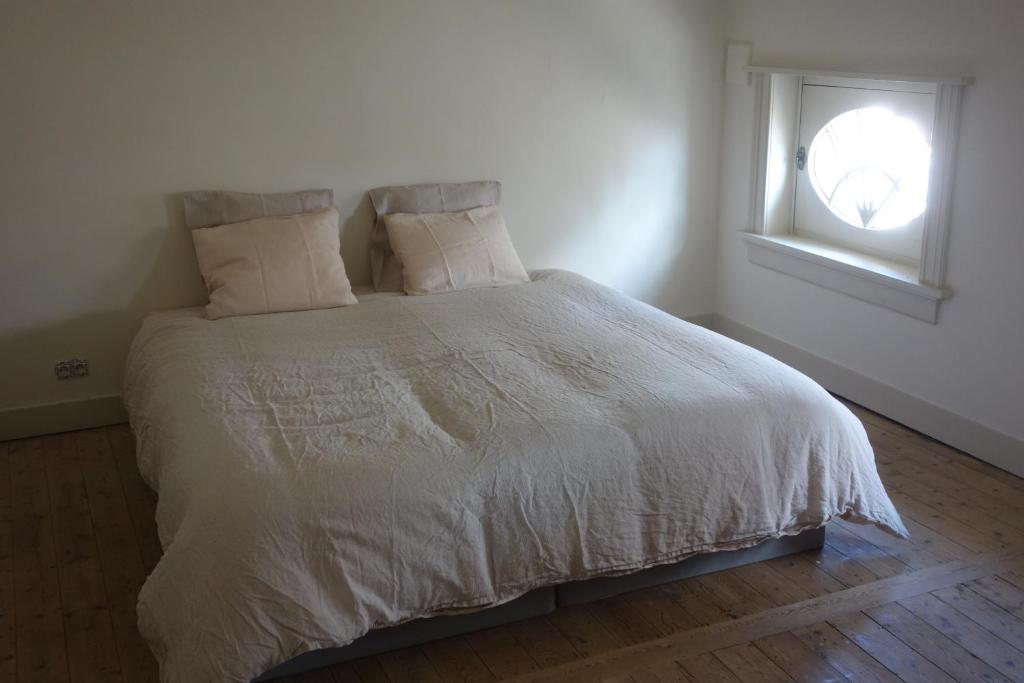 a bedroom with a white bed with a window at Studio Minerva in Antwerp