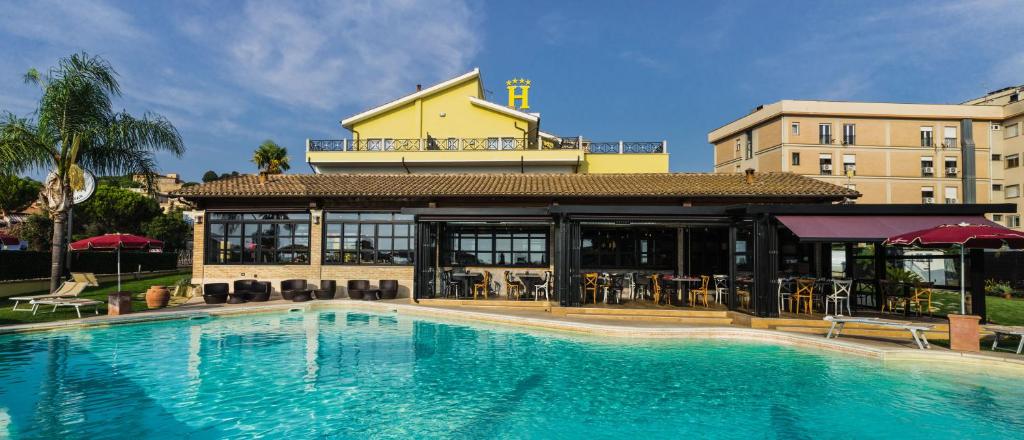 une grande piscine en face d'un bâtiment dans l'établissement Hotel Villa Tirreno, à Tarquinia