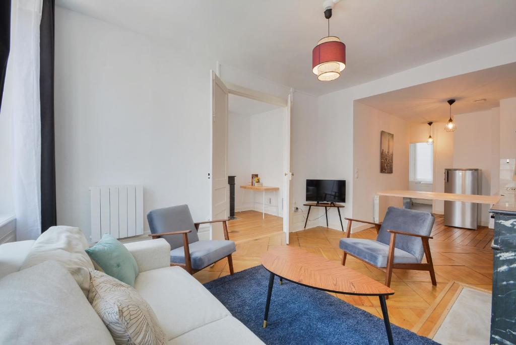 a living room with a white couch and chairs at Le coeur des Dominicains in Nancy