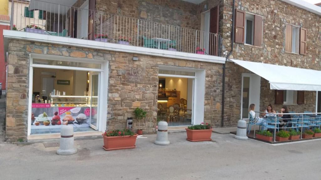 a store front of a brick building with potted plants at 103 Boutique Hotel Stintino in Stintino