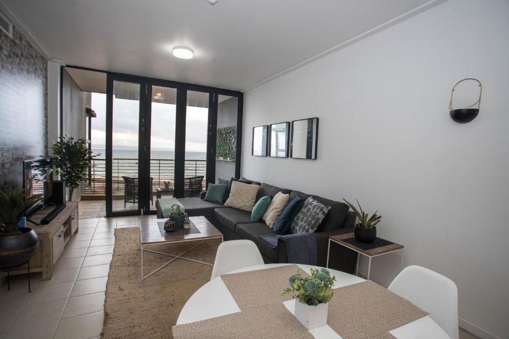 a living room with a couch and a table at Stay at The Point- Happy Homely Horizons in Durban