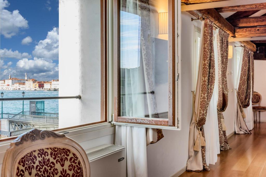 a room with a balcony and a window overlooking the ocean at Al Redentore Di Venezia in Venice