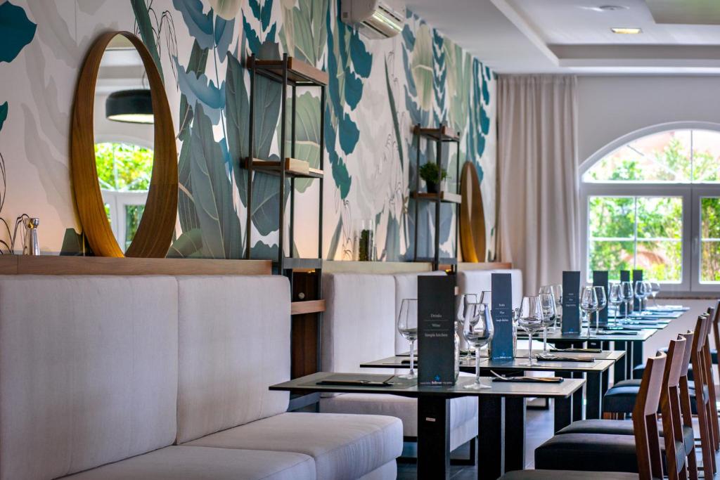 een rij tafels in een restaurant met spiegels bij Luxury Suites Bellevue in Lopar