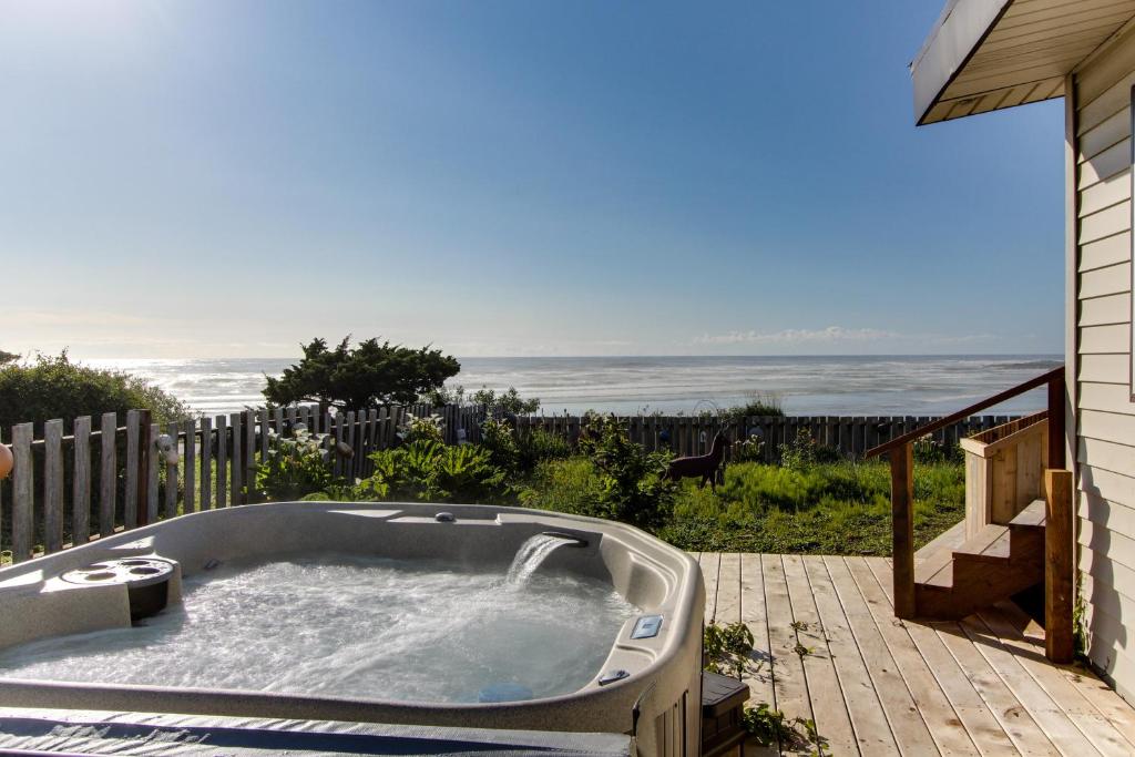 a hot tub on a patio with a view of the ocean at Patty's Sea Perch in Yachats