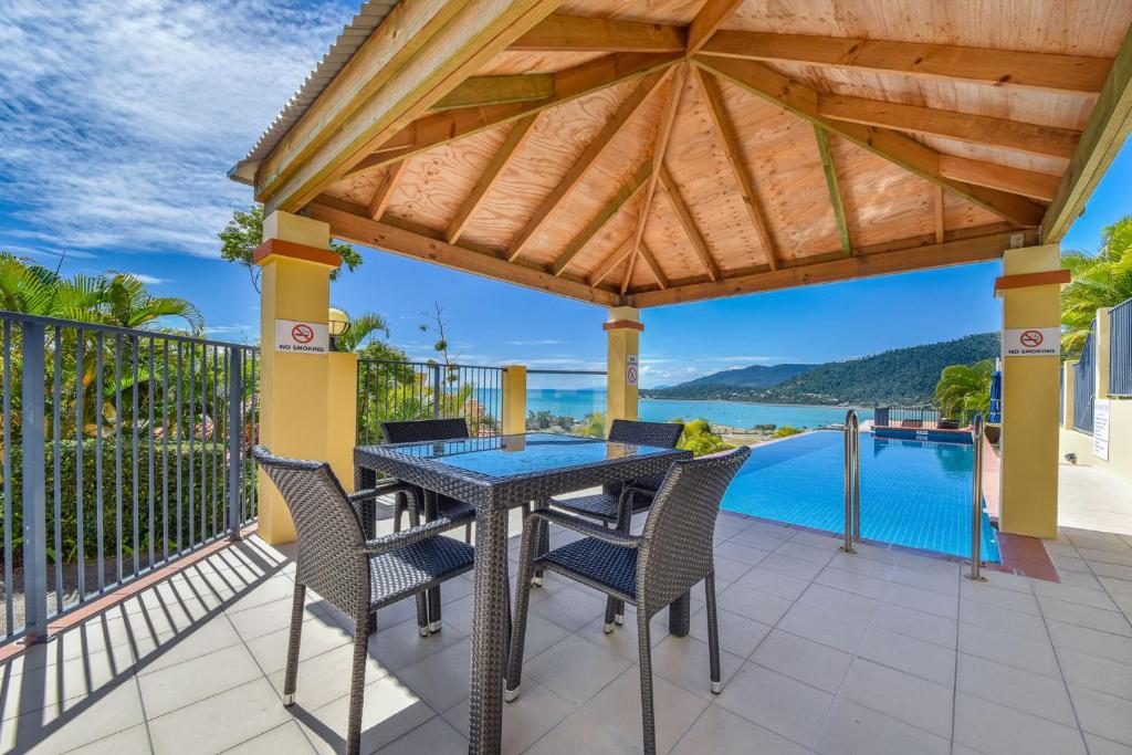 a patio with a table and chairs and a view of the water at Casa Oceana - Airlie Beach in Airlie Beach