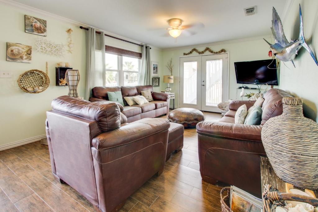 a living room with two leather couches and a tv at Mesquite House Upstairs Unit in South Padre Island