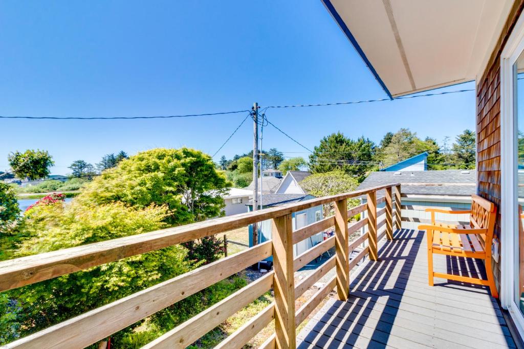 a porch with a wooden railing and benches on a house at Elli's Haus in Rockaway Beach