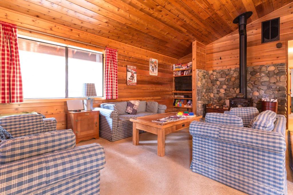 a living room with couches and a table in a cabin at Ford Family Escape in Truckee