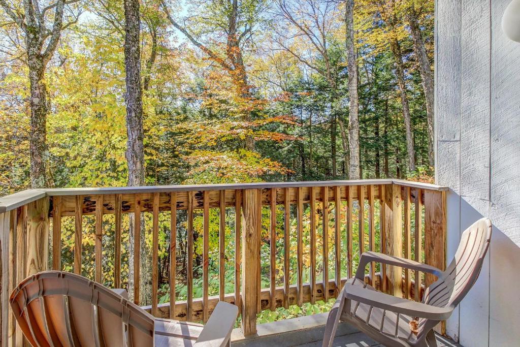 a porch with two chairs and a view of the woods at Bridges 25 in Sugarbush Village
