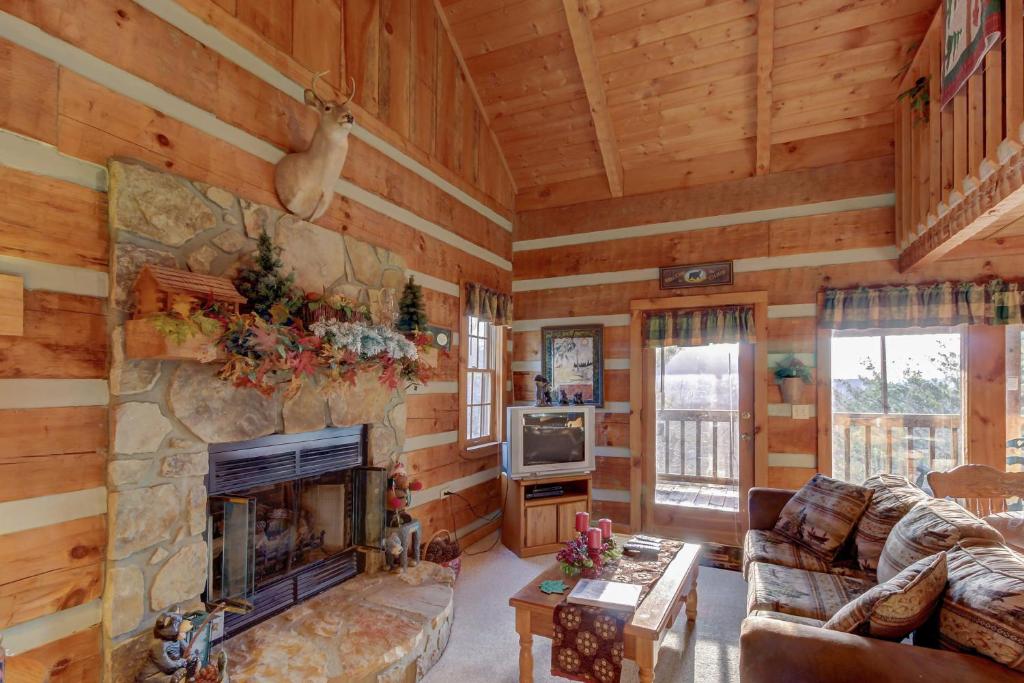 a living room with a stone fireplace in a log cabin at Misty View Cabin in Hatchertown