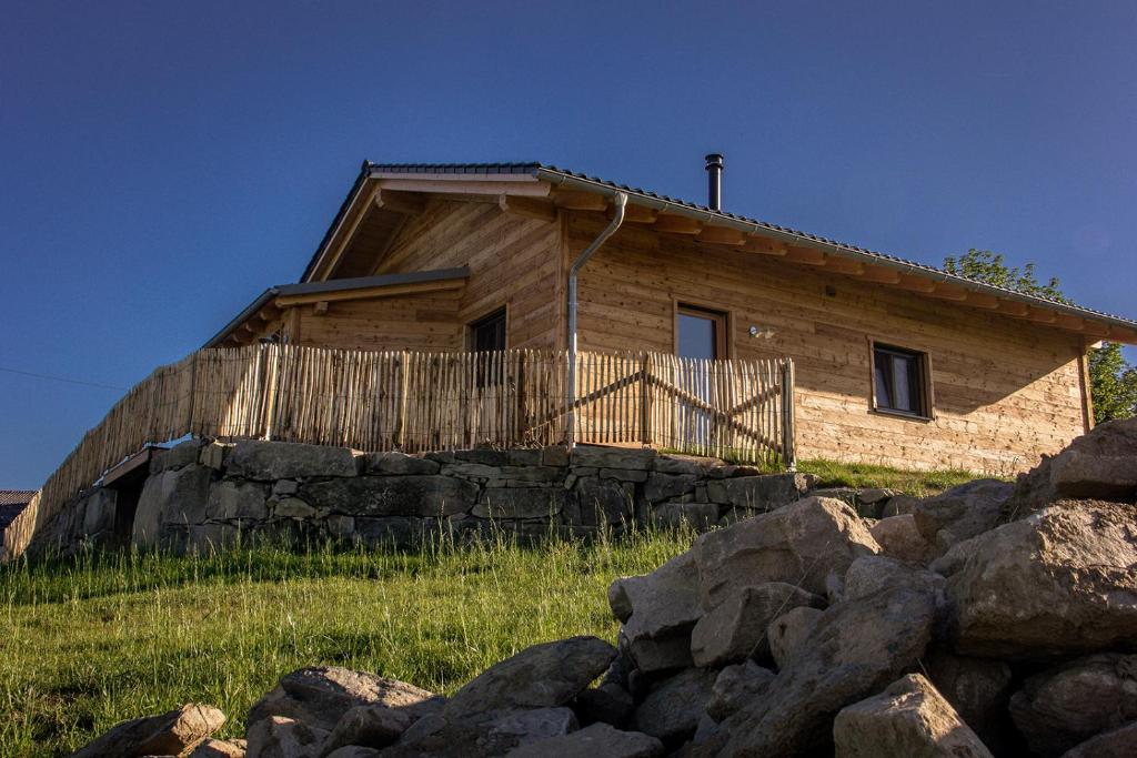 une maison en bois au sommet d'une colline avec des rochers dans l'établissement Ferienhof Jakob Rohrhof, à Jandelsbrunn