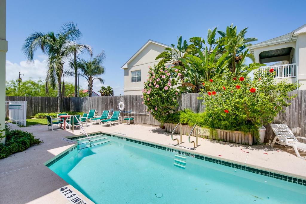 a swimming pool in a yard with chairs and a fence at Cloud Dancer Condos in South Padre Island