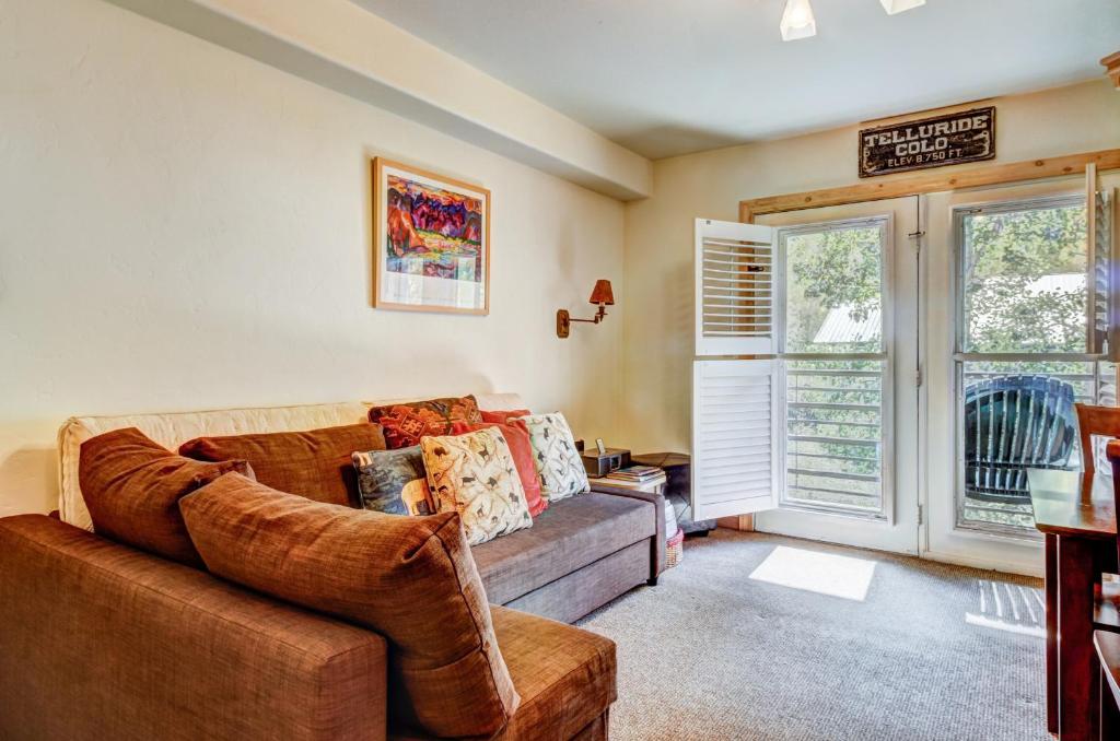 a living room with a couch and two windows at Viking Lodge B218 in Telluride