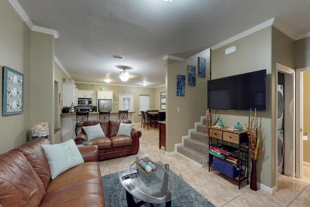 a living room with leather couches and a flat screen tv at Pura Vida Unit A in South Padre Island