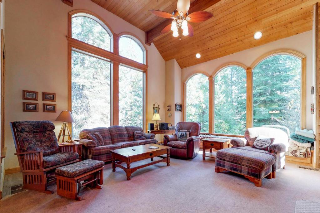 uma sala de estar com mobiliário e uma ventoinha de tecto em New England Cottage em Shaver Lake