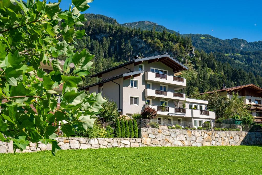 
a large stone building with a view of the mountains at Apart Gruber in Ramsau im Zillertal
