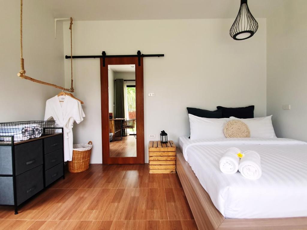 a bedroom with a bed with two towels on it at Coconut Wells Phuket in Chalong