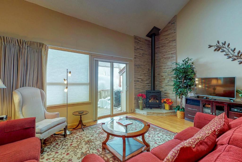a living room with a red couch and a fireplace at Lodge 3007 in Pagosa Springs