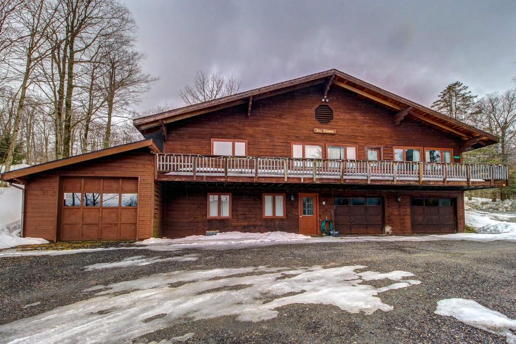 a large wooden house with a balcony on top at Alpine Drive Adventure in Telemark Village