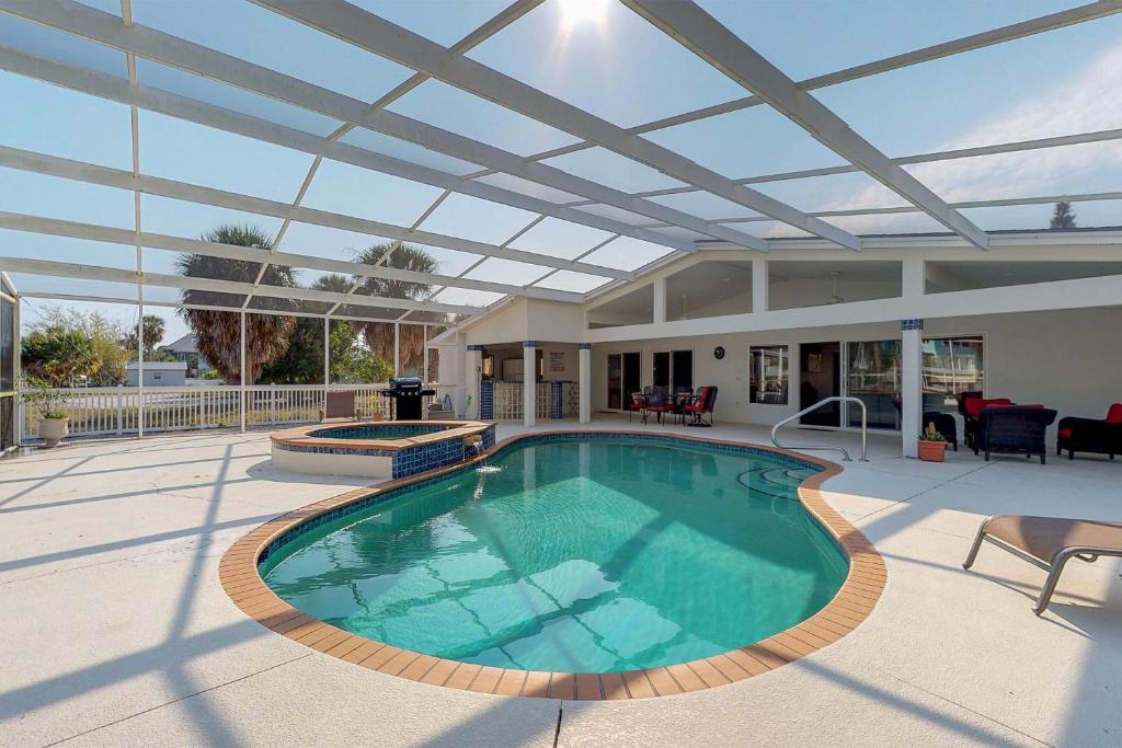 a large swimming pool with a roof on a patio at Anna Maria's Finest in Anna Maria