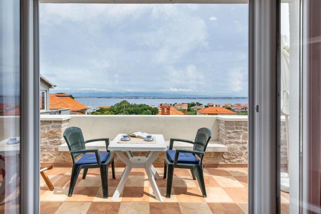 a view from the balcony of a house with a table and chairs at Sea view suite Mateo in Preko