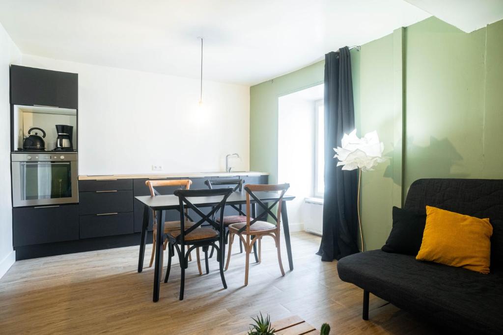 una cucina e un soggiorno con tavolo e sedie di Ker Iliz a Bédée