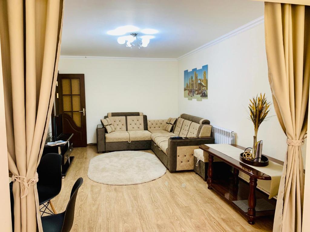 sala de estar con sofá y mesa en Samarkand Apartment, en Samarkand