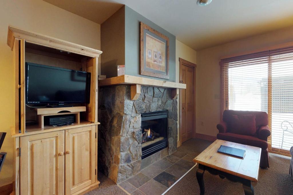 a living room with a fireplace and a television at Red Hawk Lodge 2200 in Dillon