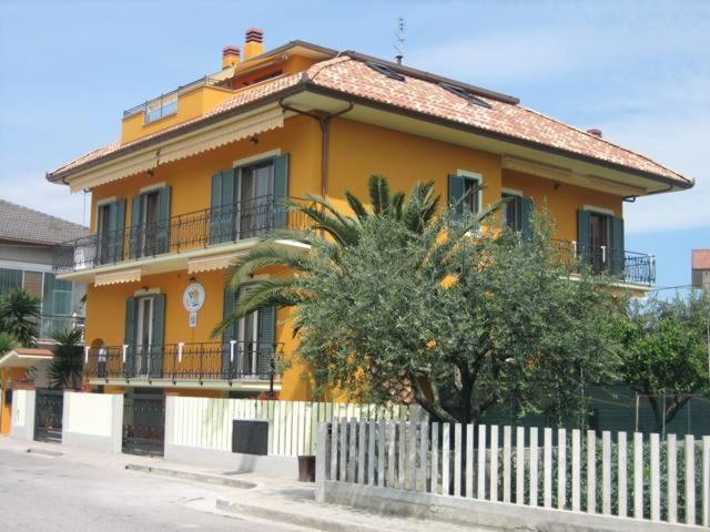 マルティンシクーロにあるVilla Consortiの白い柵の黄色い家