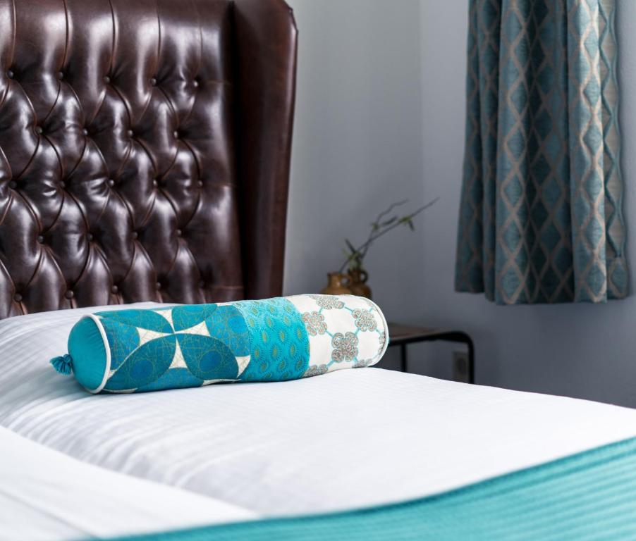 un cuscino blu seduto sopra un letto di Hotel Centraal a Someren