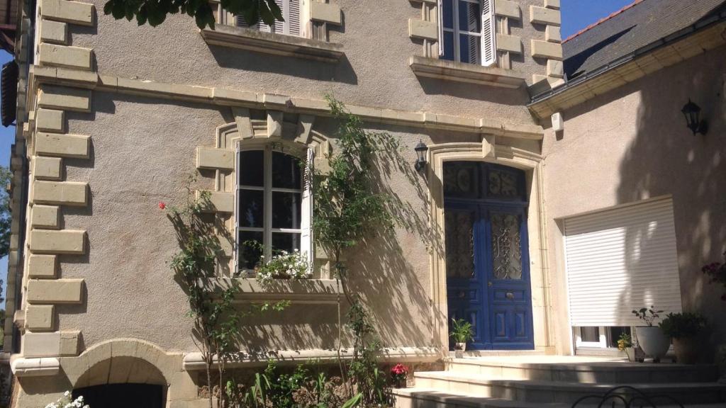 ein Haus mit einer blauen Tür und einem Fenster in der Unterkunft Manoir la Rumillette in Saint-Michel-sur-Loire