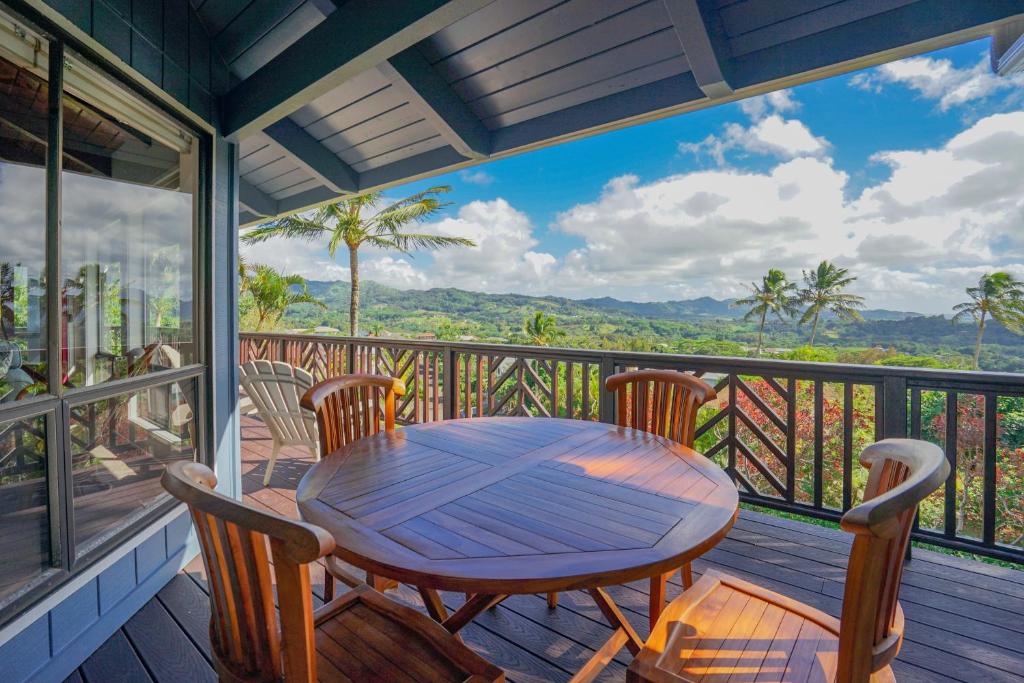 a wooden table and chairs on a balcony with a view at Kalaheo View - TVNC 5018 in Kalaheo