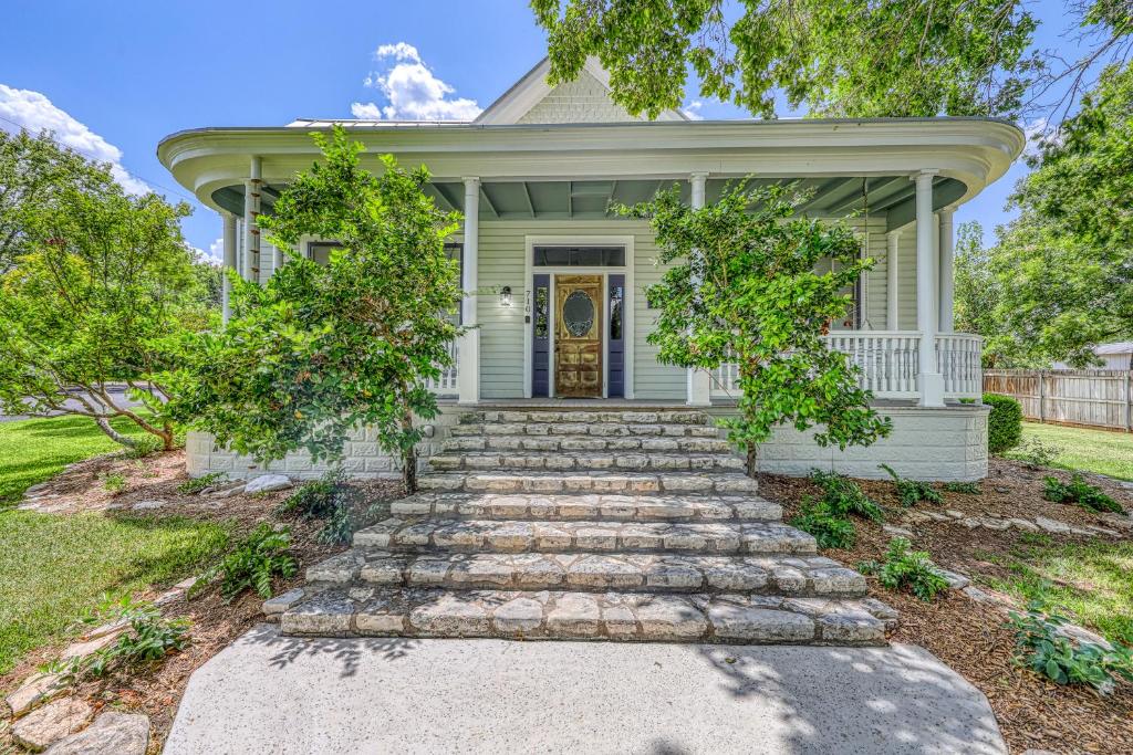 a white house with a staircase leading to the front door at Silver Lining 1898 in Fredericksburg