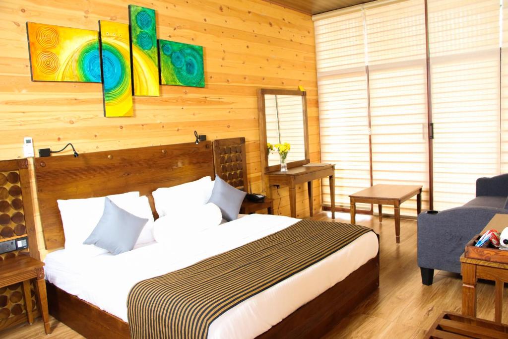 a bedroom with a bed in a room with wooden walls at Aloft Grand Hotel Ella in Ella