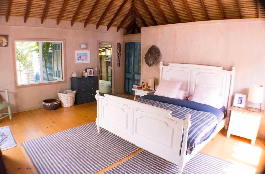 um quarto com uma grande cama branca num quarto em The Island Retreat em Kooringal
