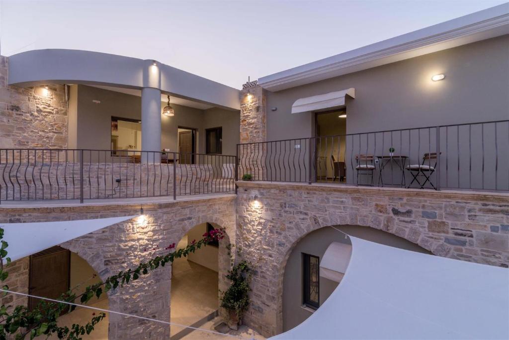 a house with a stone wall and a balcony at Mokamvilia in Petrokefálion