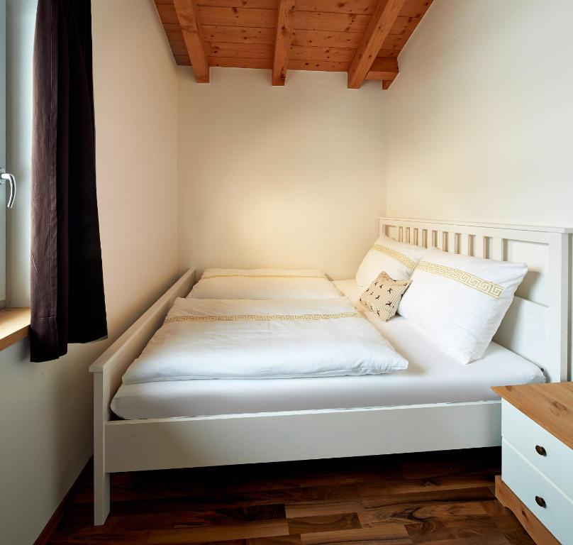 a small bedroom with a white bed in a room at Kitz Mountain Living in Aurach bei Kitzbuhel